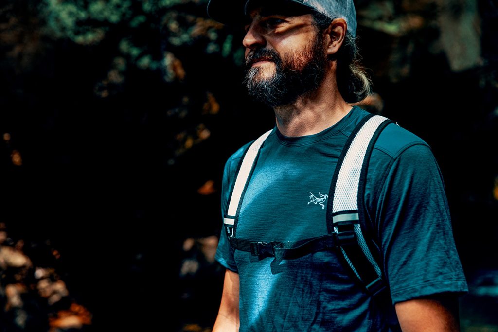 A young outdoor enthusiast wears a white comfort strap Vayska hydration pack in the outdoors.