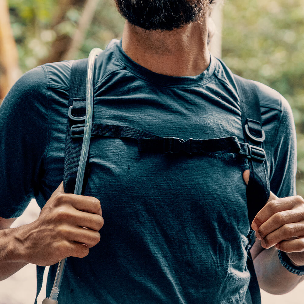 A young outdoor enthusiast wears a regular strap Vayska hydration pack in nature.