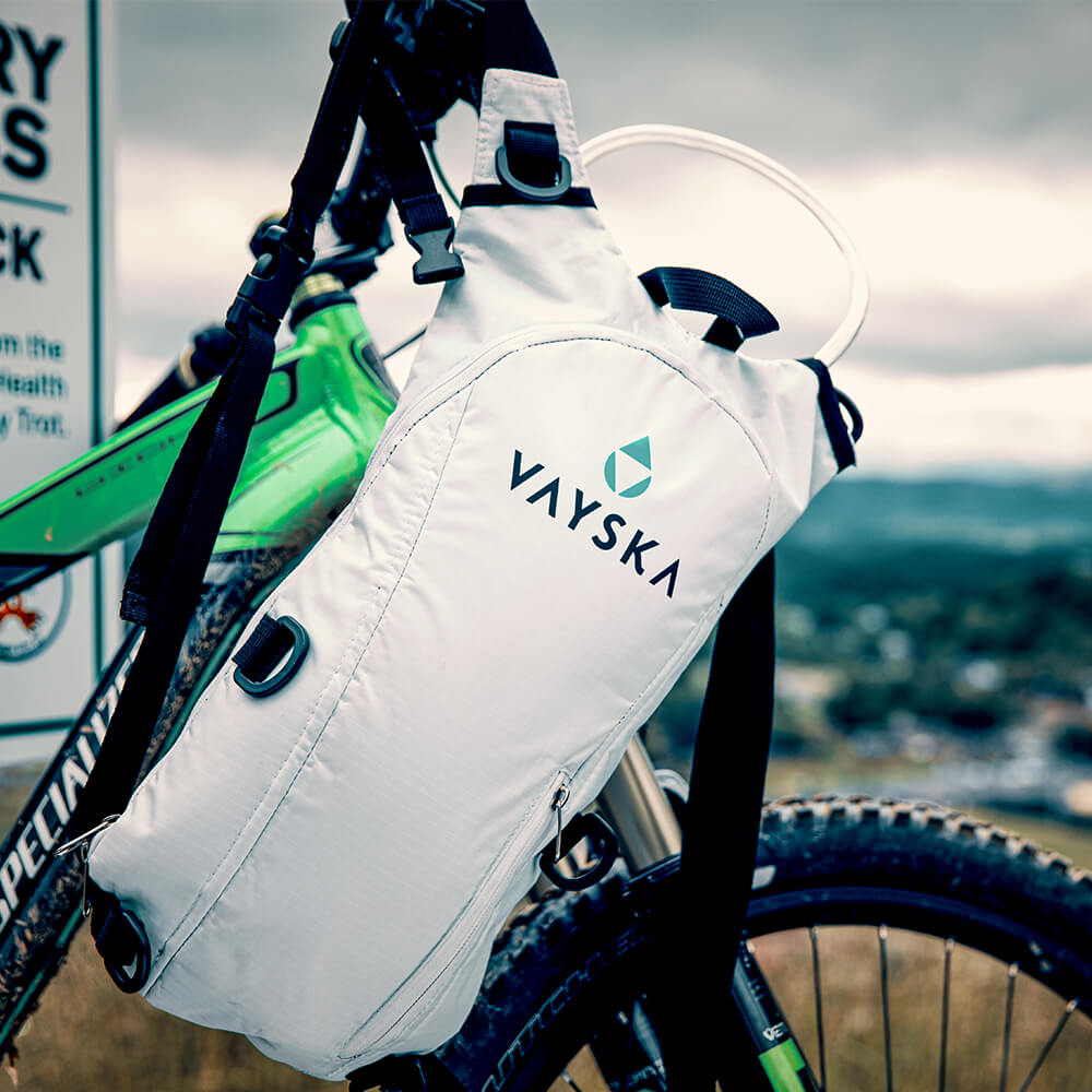 White hydration backpack hanging from a mountain bike